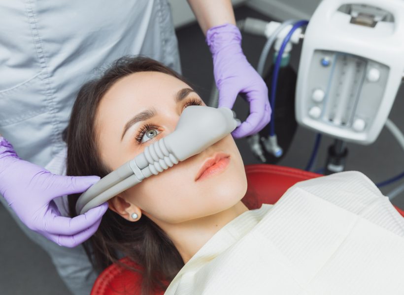 dentist puts inhalation sedative mask on his patient.