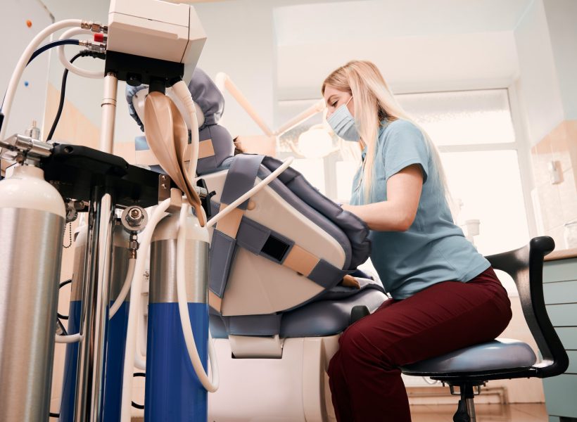 Female dentist checking child teeth in dental office.